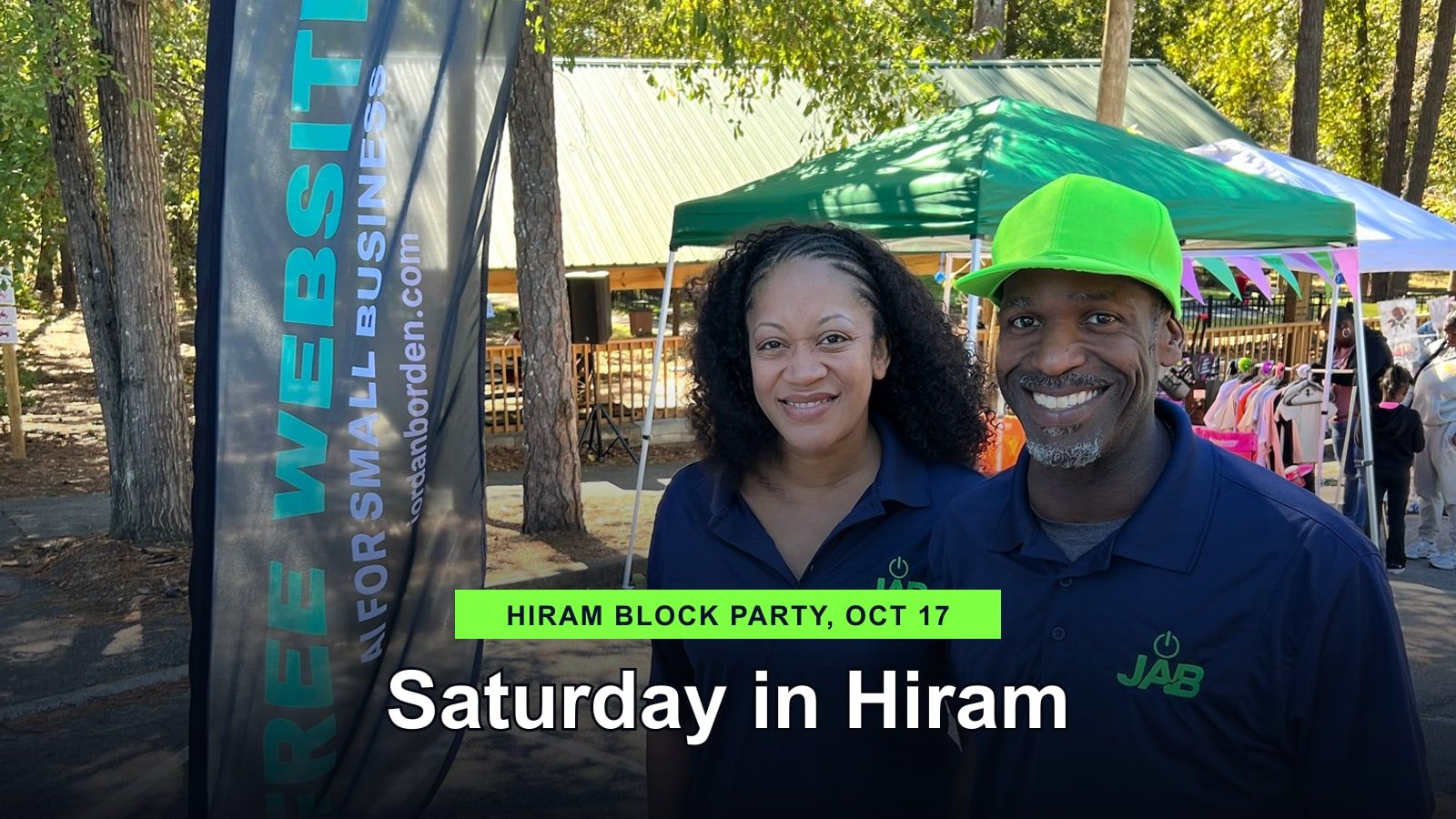 Alysia Borden and Walter Jordan in JAB polos beside the Free Websites flag at the Hiram block party
