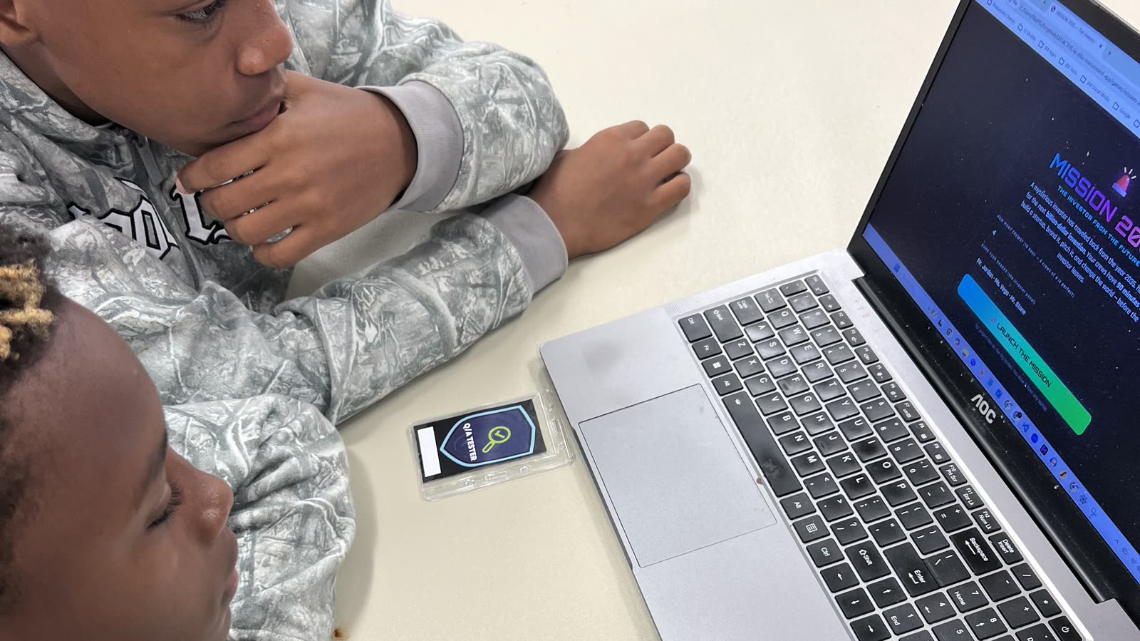 Two students focused on a laptop screen during the build sprint